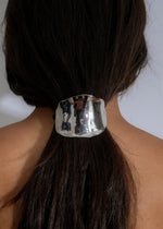 Radiant Hold Hair Tie Silver shining in the sunlight, holding hair in a sleek and elegant style