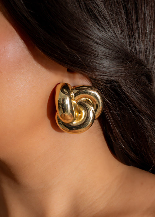 A close-up image of the You Can't Be Me Earring Gold, showcasing its intricate design and luxurious gold finish