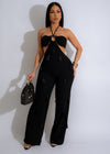 Close-up of elegant black knit jumpsuit with gold accents on model