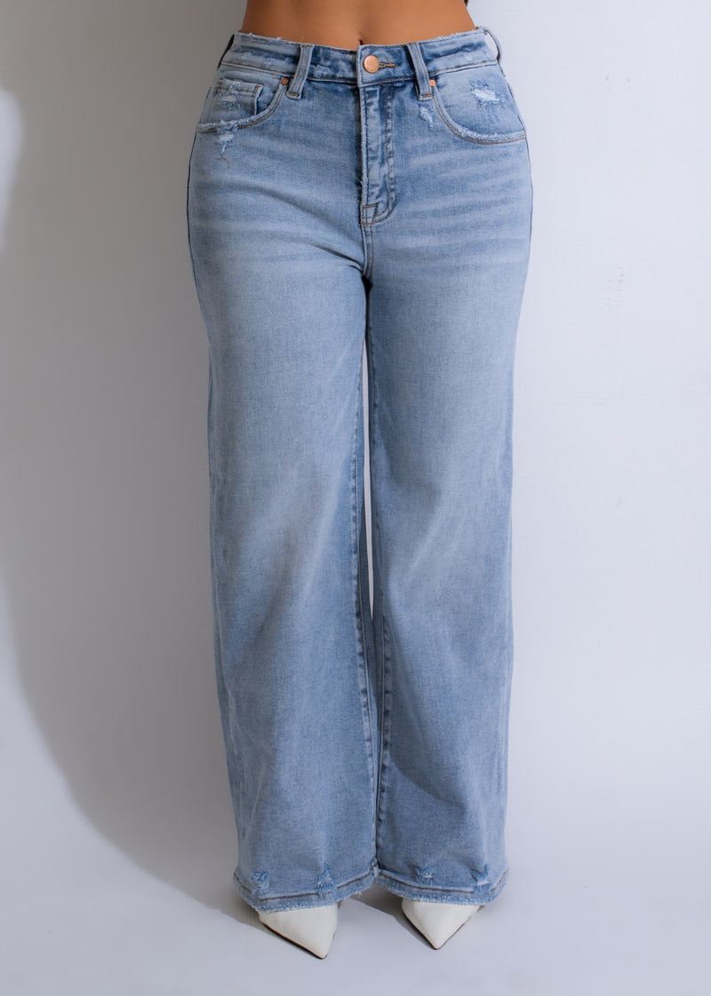  Close-up of light denim distressed jeans with a skyward dream design