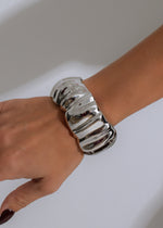 Shiny silver chrome wave bracelet with intricate interlocking design and clasp