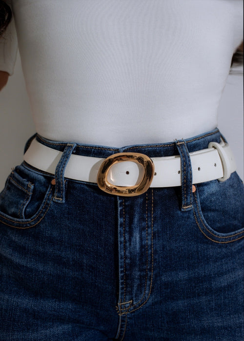 Close-up of elegant white oval belt with gold buckle on display 