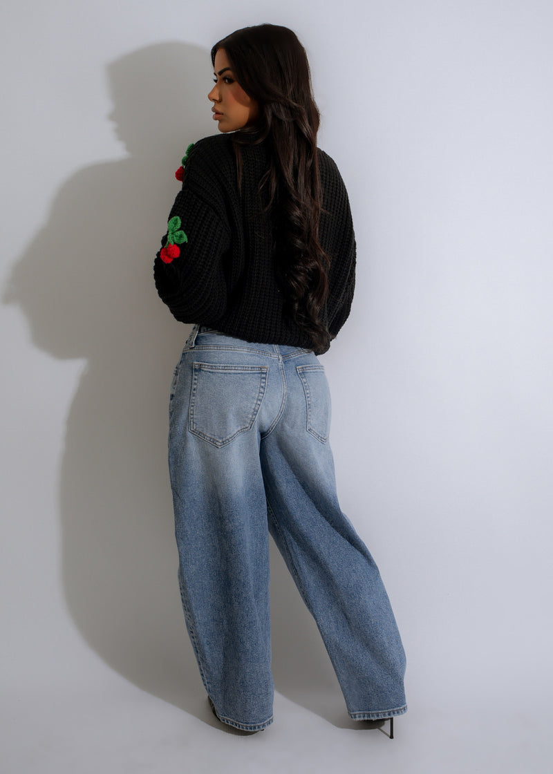  A woman wearing the Cherry Pop Sweater Knit Black, showcasing its flattering fit and versatility