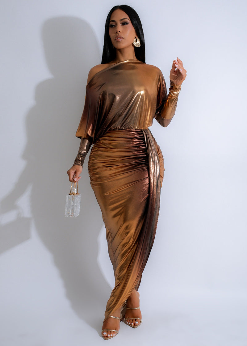 Close-up image of Solaris Drape Ruched Metallic Maxi Dress Gold, showcasing its elegant ruched details and shimmering metallic fabric