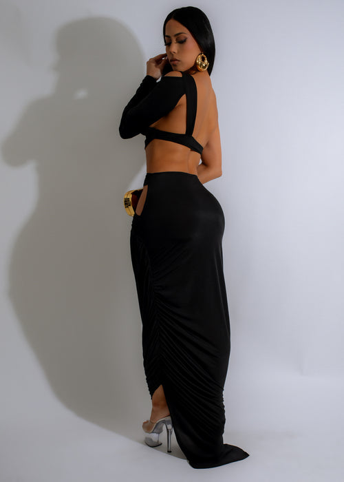  Side view of the Obsidian Knot Ruched Maxi Dress in black, showcasing the flowy and floor-length silhouette, perfect for a formal evening event or a special occasion