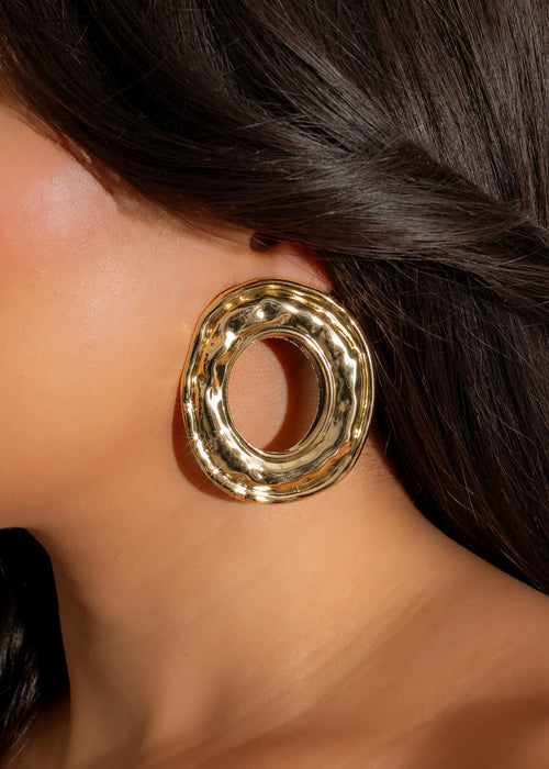 Shiny gold oval earrings with ripple design, a perfect statement accessory