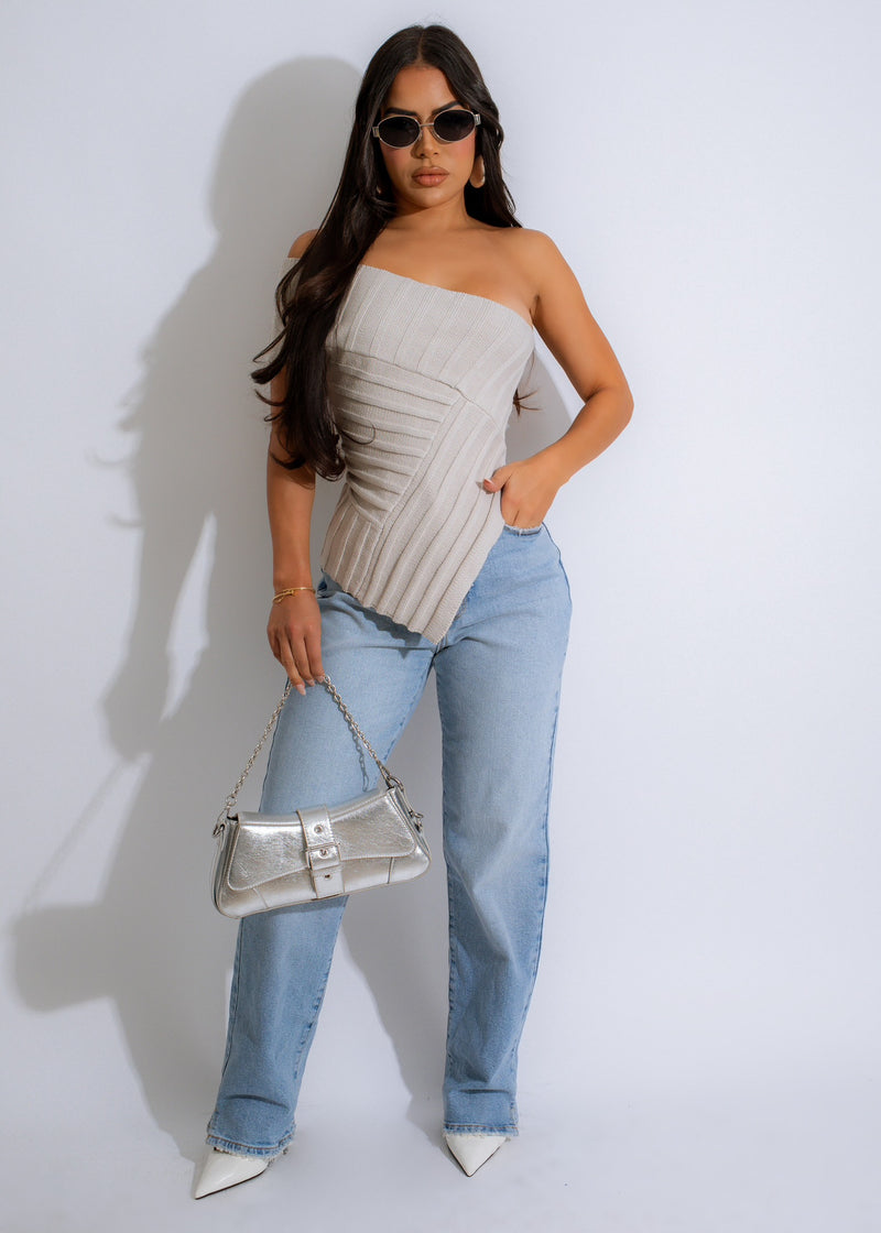 Close-up of a woman wearing a nude knit crop top, sitting comfortably and looking stylish