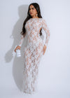 Obsidian Flora Lace Ruched Maxi Dress White on a woman standing by the beach with the wind blowing her dress