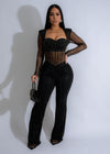 Close-up of black mesh jumpsuit with rhinestone embellishments and orchid design