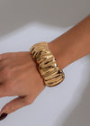 Stunning gold chrome wave bracelet with intricate details and elegant design