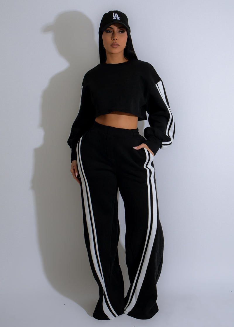 Close-up of a woman wearing a black Street Pulse Stripes Pant Set, featuring trendy white stripes and a comfortable, stylish design