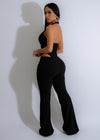 An elegant and luxurious black jumpsuit with a gilded drape design