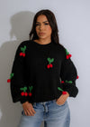  Close-up of the intricate knit pattern on the Cherry Pop Sweater in classic black