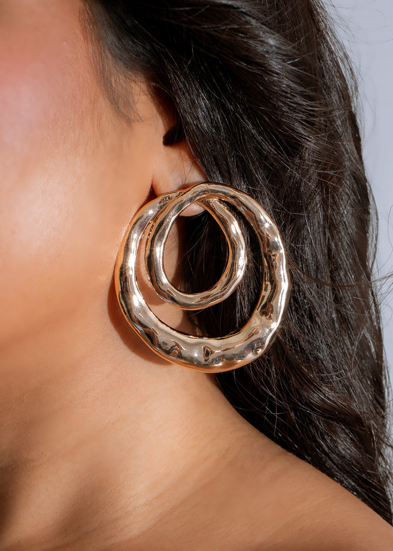 Shimmering gold hoop earrings with celestial-inspired ripples design, perfect for any occasion