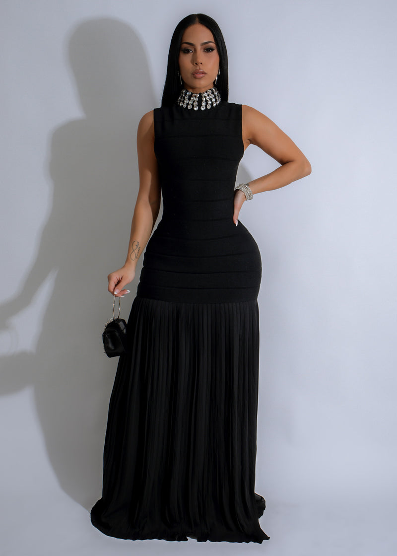 Close-up of black maxi dress with ribbed texture and rhinestone embellishments on the bodice and sleeves, creating a glamorous and elegant look