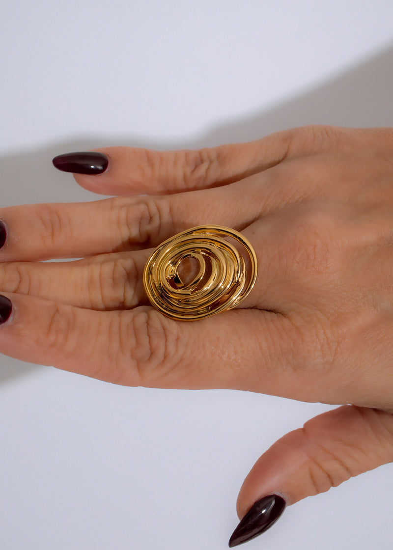  Beautifully crafted Orbit Twist Ring Gold displayed on a delicate hand, accentuating its timeless elegance and sophisticated allure