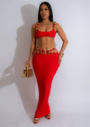 Close-up of red beaded skirt with golden embellishments and matching crop top set on mannequin