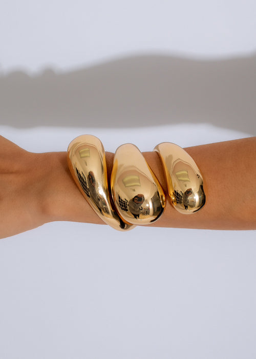 Shimmering golden wave cuff bracelet with intricate design and lustrous finish