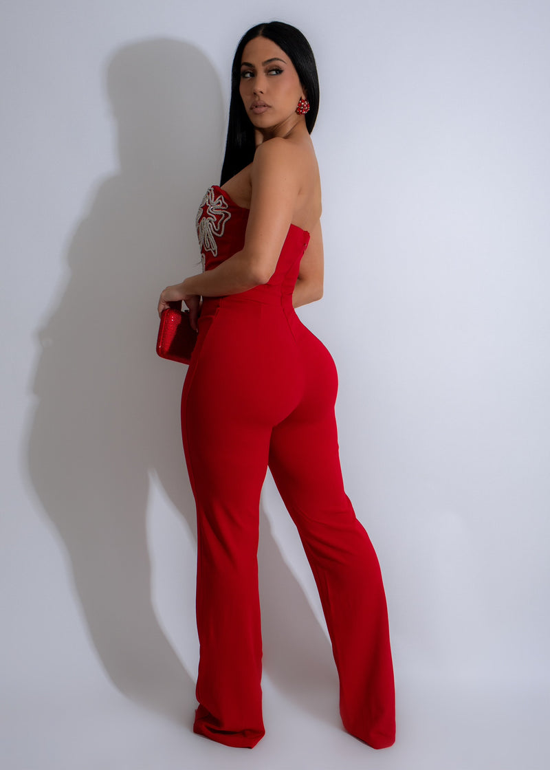  Full-length photo of a woman wearing the red jumpsuit with rhinestone detailing, showcasing the elegant and luxurious design