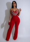 Close-up image of red jumpsuit with celestial bloom rhinestones embellishments on the bodice and sleeves, perfect for a glamorous evening look