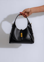 The Luxe Crescent Black: A stylish and sleek black leather handbag with a crescent shape and gold accents, perfect for a night out or special event