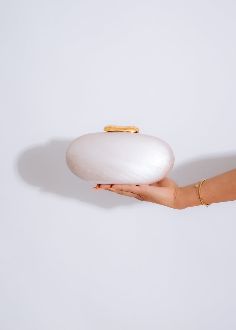 Beautiful nude oval clutch with elegant design and gold hardware details