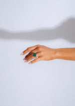  Elegant hand wearing the 'Made You Look Ring Green' against a natural backdrop, showcasing its stunning color and design