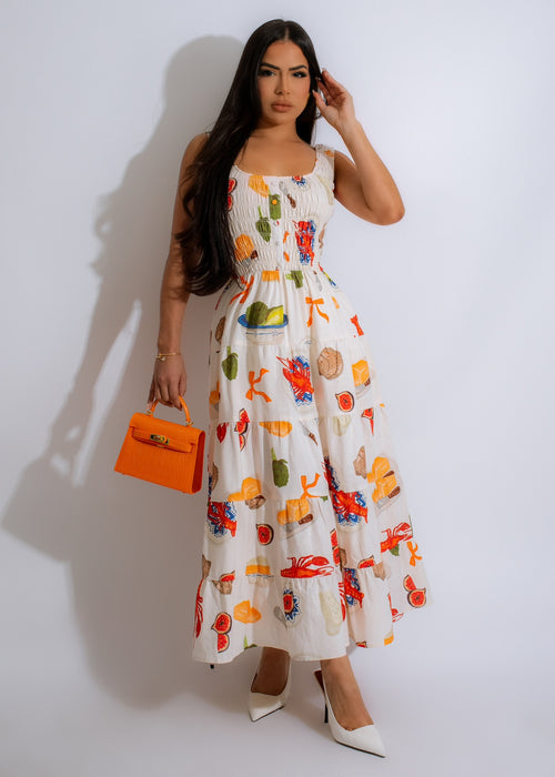 Beautiful woman wearing a flowy nude maxi dress under a sunny blue sky with white clouds and green trees in the background