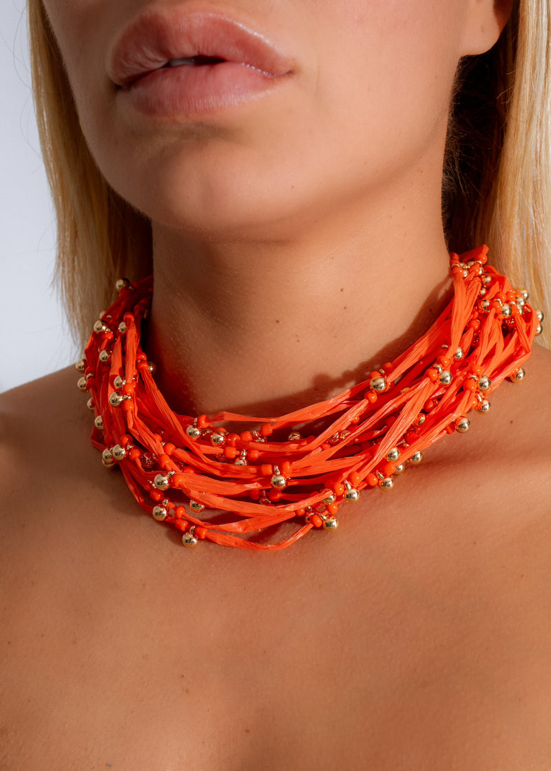 Handmade orange beaded necklace with tassel, perfect for adding a pop of color to your summer outfits