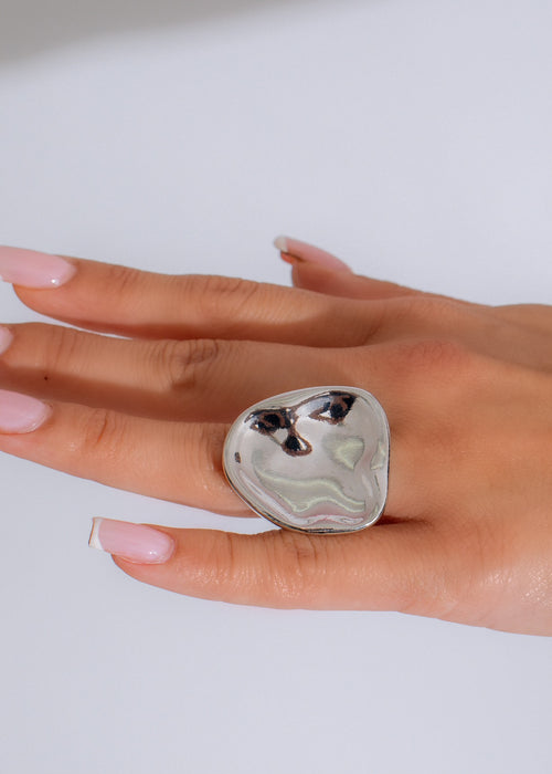 Close-up of silver ring with intricate emotional design and shimmering finish